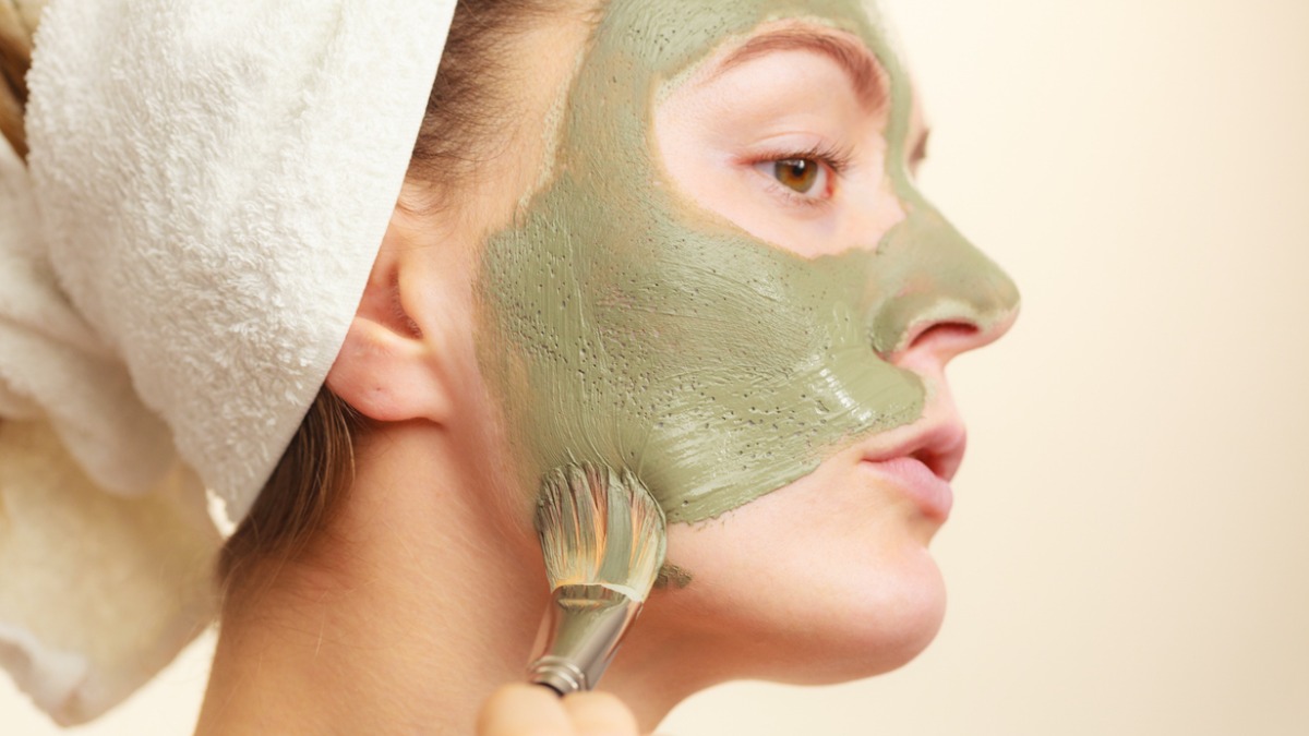 Une femme applique un masque à l'argile sur son visage